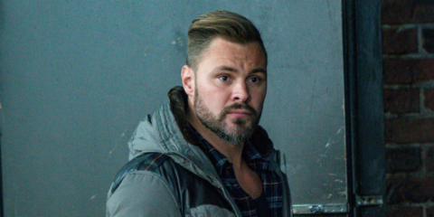 Patrick Flueger poses a picture in a grey jacket.